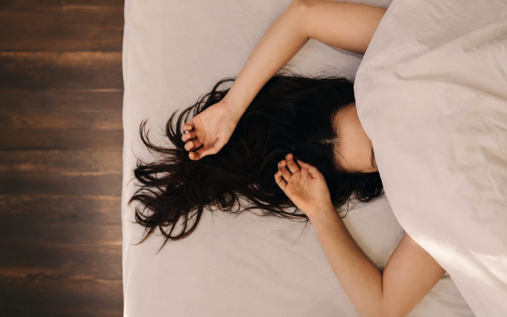 Femme dans son lit évoquant un sommeil serein
